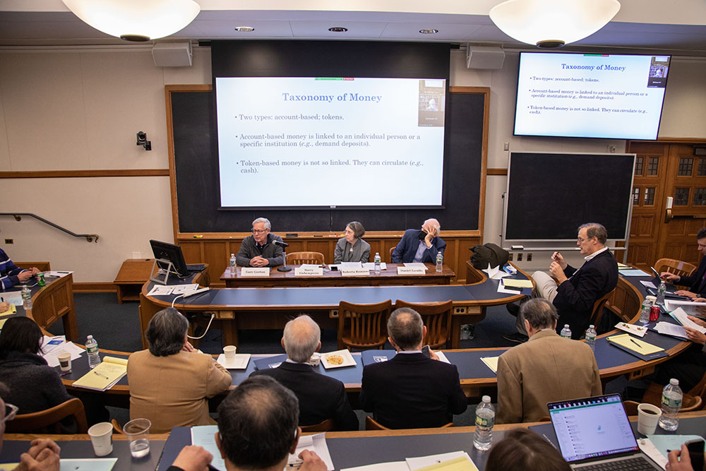 Yale SOM Prof. Gary B. Gorton (far left) presenting, while YLS Prof. and Center Dir. Roberta Romano &#039;80 (center), Berkeley Econ. Prof. Barry Eichengreen (in small screen window), and Harvard Law Prof. Daniel K. Tarullo (right) listen