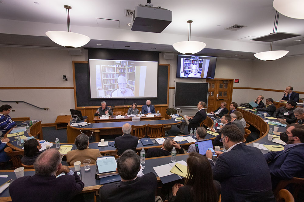 Yale SOM Prof. Gary B. Gorton (far left) answering a question, while YLS Prof. and Center Dir. Roberta Romano &#039;80 (center), Berkeley Econ. Prof. Barry Eichengreen (on screen), and Harvard Law Prof. Daniel K. Tarullo (right) listen