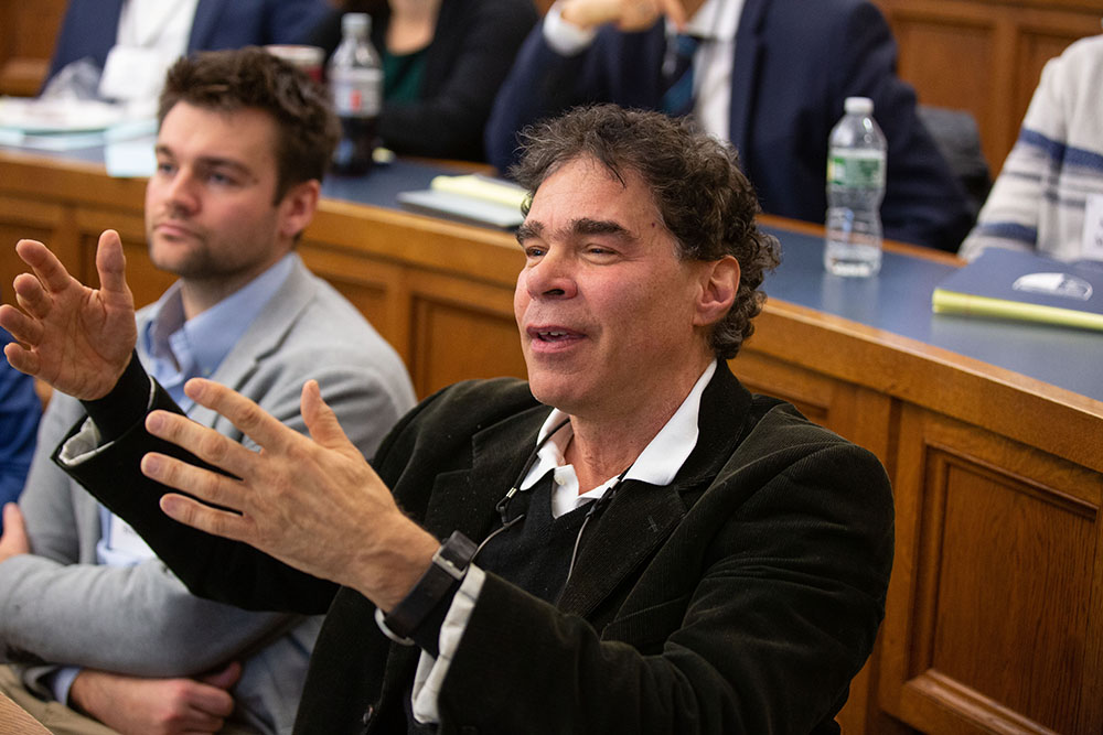 Yale Econ. Prof. John Geanakoplos asking a question, while Christopher Bruno (left) listens